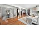 Open-concept living space with hardwood floors, white walls, and seamless transitions to dining and kitchen areas at 3608 S Newport Way, Denver, CO 80237