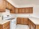 Kitchen with oak cabinets, white appliances, and ample counter space at 1390 E Southern St, Brighton, CO 80601