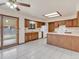 Kitchen with oak cabinets, tiled floor, island, and sliding door to backyard at 1390 E Southern St, Brighton, CO 80601