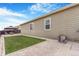 Backyard boasts a grassy area, small patio with gravel, and a view of the home's exterior at 581 Park Blvd, Brighton, CO 80603