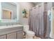 Bathroom features a modern vanity with an illuminated mirror and a shower with gray curtain at 581 Park Blvd, Brighton, CO 80603