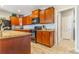 Kitchen boasts sleek black appliances, wood cabinets, and countertops with an attractive tiled backsplash at 581 Park Blvd, Brighton, CO 80603