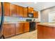Kitchen boasts sleek black appliances, wood cabinets, and countertops with an attractive tiled backsplash at 581 Park Blvd, Brighton, CO 80603