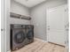 Laundry room featuring gray washer and dryer units, neutral walls, and a simple shelf for storage at 581 Park Blvd, Brighton, CO 80603