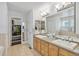 Bright bathroom with double sinks, wooden cabinets, and access to a spacious walk-in closet at 8865 E 28Th Ave, Denver, CO 80238