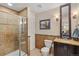 Well-lit bathroom featuring a glass-enclosed shower, vanity with granite countertop, and tiled walls at 8865 E 28Th Ave, Denver, CO 80238