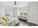 Bright bedroom with a ceiling fan, dresser, and large windows overlooking the neighborhood at 8865 E 28Th Ave, Denver, CO 80238