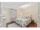 Cozy bedroom features a floral comforter, window with curtains, and decorative chandelier lighting at 8865 E 28Th Ave, Denver, CO 80238