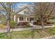 Inviting yellow home featuring a cozy front porch and mature trees at 8865 E 28Th Ave, Denver, CO 80238