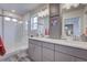 Modern bathroom featuring double sinks, sleek cabinetry, and a glass-enclosed shower at 1206 Sugarloaf Ln, Erie, CO 80516