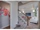 Cozy living room showcasing staircase, powder room, and entertainment area with TV and neutral decor at 1206 Sugarloaf Ln, Erie, CO 80516