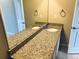 Bathroom featuring a double sink vanity with granite countertops, large mirror, and neutral wall color at 14673 E Belleview Dr, Aurora, CO 80015