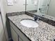 Close-up on a bathroom vanity with a granite countertop, white cabinets, and a modern faucet at 14673 E Belleview Dr, Aurora, CO 80015
