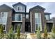 Modern townhome with gray brick and siding, a walkway to the front door, and young evergreens for curb appeal at 14673 E Belleview Dr, Aurora, CO 80015