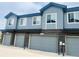 Modern townhome garages with gray doors and brick accents offering convenient parking and contemporary design at 14673 E Belleview Dr, Aurora, CO 80015