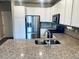Stylish kitchen featuring stainless steel appliances, granite countertops, white cabinets, and an island with a sink at 14673 E Belleview Dr, Aurora, CO 80015