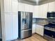 Kitchen with stainless steel refrigerator, white cabinets and granite counters at 14673 E Belleview Dr, Aurora, CO 80015