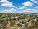 An expansive aerial view showcasing a neighborhood with lush greenery and well-maintained homes under a bright blue sky at 24422 E Frost Dr, Aurora, CO 80016