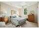 Sunlit bedroom with a floral quilt, patterned pillows, and matching dressers at 24422 E Frost Dr, Aurora, CO 80016