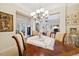 Bright dining room with wood table, seating for six, and elegant chandelier leading into adjoining rooms at 24422 E Frost Dr, Aurora, CO 80016