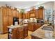 Traditional kitchen boasts wood cabinetry, granite countertops, and a center island at 24422 E Frost Dr, Aurora, CO 80016