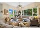 Inviting living room showcasing curved sofas, an ottoman, and large windows with lush outdoor views at 24422 E Frost Dr, Aurora, CO 80016