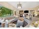 Cozy living room with tufted sofas, a fireplace, and large windows overlooking a green yard at 24422 E Frost Dr, Aurora, CO 80016