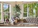 Bright living room with large windows, a plush sofa, and a view of the outdoor greenery at 24422 E Frost Dr, Aurora, CO 80016