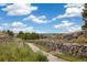 Scenic walking path lined with stone walls and lush greenery offering a peaceful outdoor experience at 24422 E Frost Dr, Aurora, CO 80016