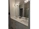 Elegant bathroom featuring double sinks, white cabinets, and a large mirror with modern lighting at 6761 Meade Cir, Westminster, CO 80030