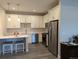 Bright kitchen featuring white cabinets, stainless steel appliances, and a breakfast bar with stools at 6761 Meade Cir, Westminster, CO 80030