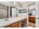 Bathroom featuring a large vanity mirror, wood cabinets, and an adjoining room with a tiled shower at 1920 S Hannibal St # B, Aurora, CO 80013