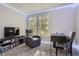 Bedroom with two windows and furnished with a reading chair, desk, chair, entertainment center and shelving at 1920 S Hannibal St # B, Aurora, CO 80013