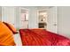 Bedroom featuring a bed with red coverlet with views to the adjoining bathroom and living room at 1920 S Hannibal St # B, Aurora, CO 80013