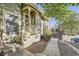 Inviting front porch with light wood railings and trim, surrounded by lush landscaping at 1920 S Hannibal St # B, Aurora, CO 80013