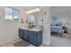 Bathroom featuring a double vanity with a blue cabinet and a doorway view to the bedroom at 2673 Live Oak Ct, Castle Rock, CO 80104