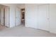 Empty bedroom showcases three doorways, white walls, and a neutral carpet, offering a blank canvas for new owners at 2673 Live Oak Ct, Castle Rock, CO 80104