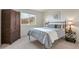 Bedroom with decorative pillows and side table lamps, complemented by a cozy bedspread and large wooden armoire at 2673 Live Oak Ct, Castle Rock, CO 80104