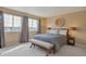 Bright main bedroom features large windows, neutral colors, and a cozy bench, with an elegant decorative piece at 2673 Live Oak Ct, Castle Rock, CO 80104