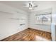 Bright bedroom featuring hardwood floors, ceiling fan, shelves and a sunlit window at 1366 Garfield St # 209, Denver, CO 80206