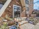 Building entrance showcases a black framed glass door, stone steps, and minimal landscaping in a brick facade at 1366 Garfield St # 209, Denver, CO 80206