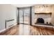 Cozy living room showcasing a fireplace, a sliding glass door to the balcony, and hardwood flooring at 1366 Garfield St # 209, Denver, CO 80206