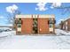 Brick apartment building featuring exterior stairways, private balconies and snow covered yard at 3623 S Sheridan Blvd # T6, Denver, CO 80235