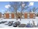 Exterior of red brick apartment building with small balconies, trees, and snow covered parking lot at 3623 S Sheridan Blvd # T6, Denver, CO 80235