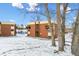 Apartment building with red brick facade, small balconies and a snow covered front lawn at 3623 S Sheridan Blvd # T6, Denver, CO 80235