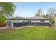 Exterior view of the home featuring a lush backyard, blue garage doors and gray and white siding at 7780 Osceola St, Westminster, CO 80030