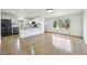Open-concept kitchen featuring white cabinets, hardwood floors, and abundant natural light in living area at 7780 Osceola St, Westminster, CO 80030