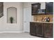 Charming basement bar area with dark wood cabinets, granite counters, and a decorative niche at 376 Dallas St, Denver, CO 80230