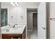 A clean and modern bathroom with marble countertops, a vanity mirror, and an open doorway to the next room at 376 Dallas St, Denver, CO 80230