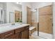 Elegant bathroom boasts a glass-enclosed shower with bench and vanity with white countertop at 376 Dallas St, Denver, CO 80230